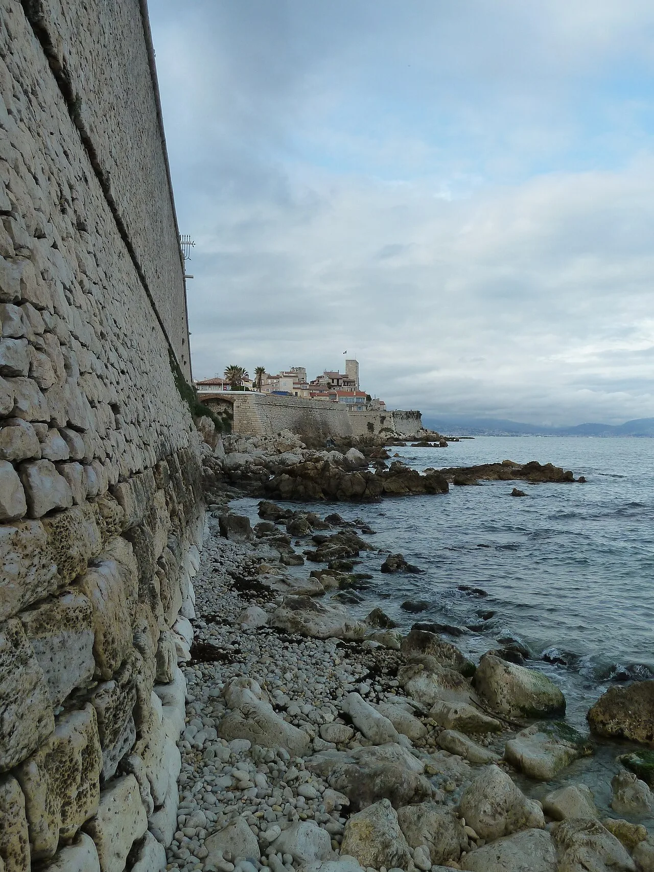 Remparts en pierre du Vieil Antibes au-dessus des rochers et de la mer.