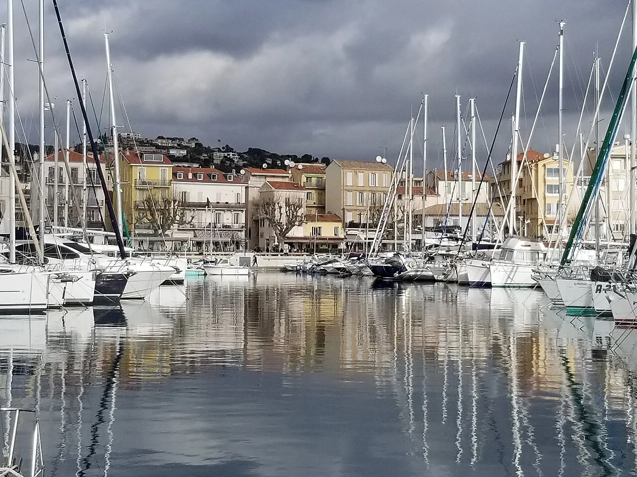 Bateaux dans le port de Golfe-Juan devant les façades colorées du front de quai.