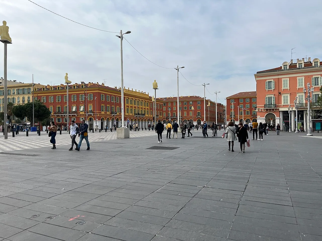 Place Masséna à Nice, façades rouges à arcades et perspective sur les rues du centre.