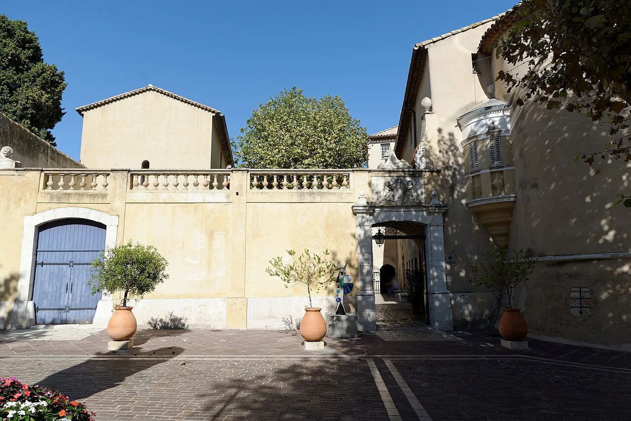 Façade du château de Vallauris, portail en pierre et pots en terre cuite sur le parvis.